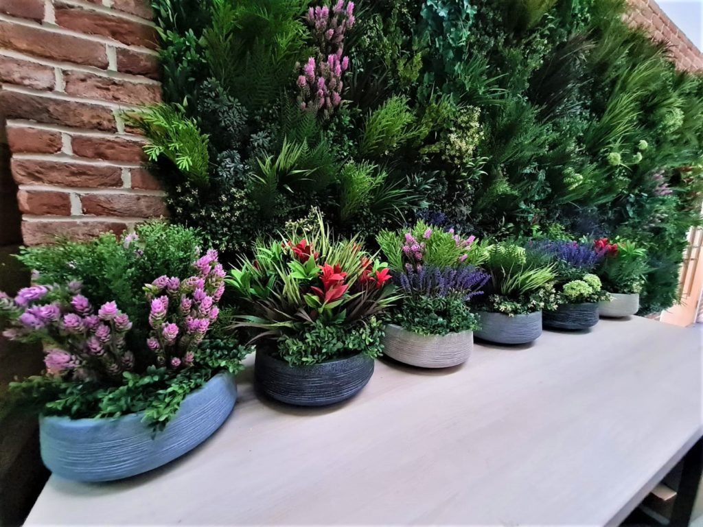Pots and planters filled with mixed artificial flowers and plants