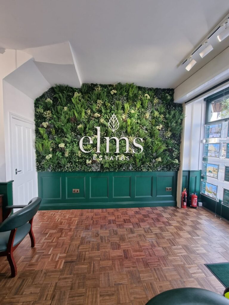 A faux green wall with a logo in an estate agent in Bethnal Green