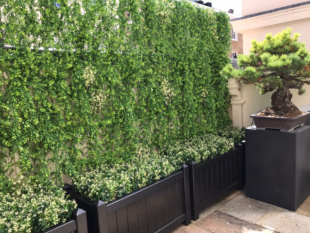 a custom fake ivy wall in a private garden in London